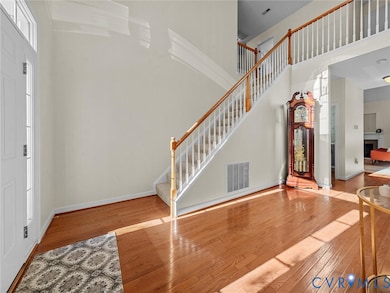 Spacious two-story foyer with hardwood floors and open staircase leading to the second level.