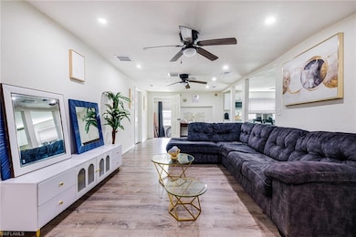 Living area featuring light wood-type flooring, recessed lighting, a ceiling fan, and plenty of natural light