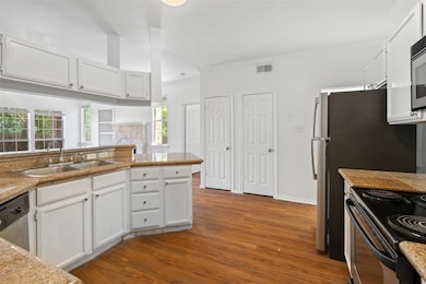 Kitchen featuring wood finished floors, appliance
