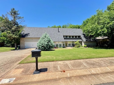 View of front of property with concrete driveway, a front yard, an attached garage, and a shingled roof