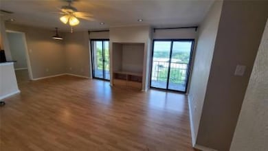 Unfurnished living room featuring wood finished f