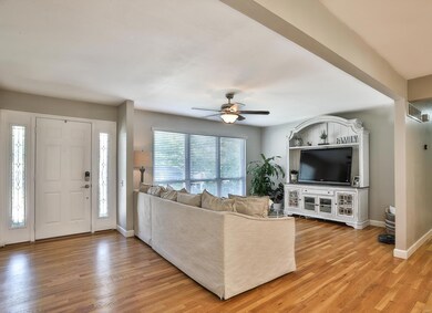 Cozy Living Room boasts a lighted ceiling fan, triple windows and Entryway with a 6 panel door and dual leaded glass sidelights.