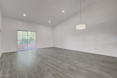 Spare room with a chandelier, lofted ceiling, dark