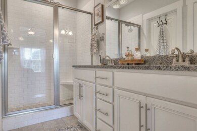 The primary bath has dual sinks, tiled shower, a private commode, and plenty of storage with cabinets along with an L-shaped extra-large master closet.