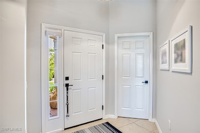 Foyer with light tile patterned floors and baseboa
