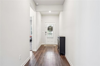 Entryway featuring baseboards and dark wood-style 