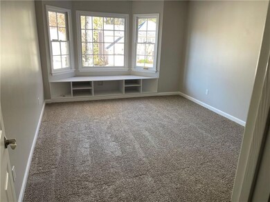 Spare room featuring carpet floors and baseboards