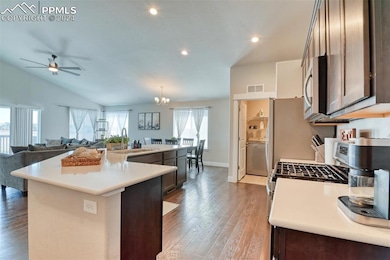 Kitchen featuring dark brown cabinetry, a wealth of natural light, sink, and a center island with sink