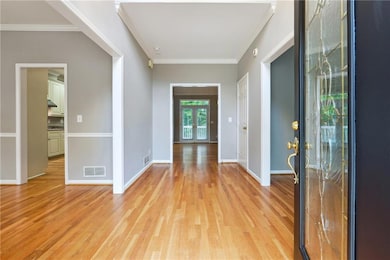 Foyer featuring light wood-type flooring and crown molding
