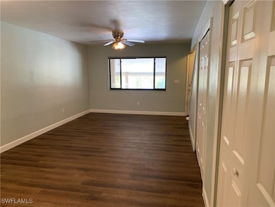 Empty room with ceiling fan and dark wood-type flo