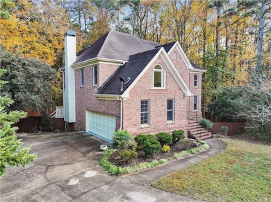 View of home's exterior with brick siding, concrete driveway, a chimney, an attached garage, and a shingled roof