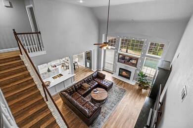 Living room featuring high vaulted ceiling, wood-type flooring, and ceiling fan