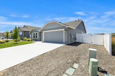 Single story home featuring a gate, an attached garage, driveway, and roof with shingles