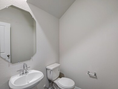 Bathroom featuring a sink, toilet, and vaulted ce