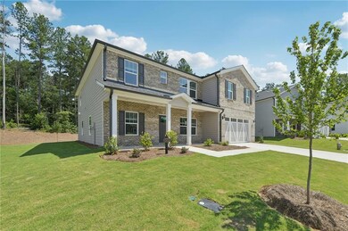 View of front facade with concrete driveway, an attached garage, a front yard, and brick siding