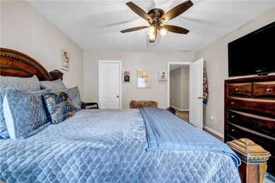 Bedroom with a ceiling fan and baseboards