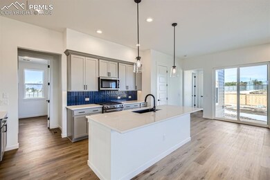Kitchen featuring gray cabinetry, sink, stainless 