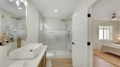 Bathroom featuring vanity, light wood-style flooring, ensuite bathroom, a stall shower, and ceiling fan