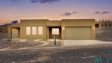 Pueblo-style house featuring stucco siding, concrete driveway, and an attached garage