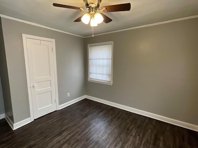 Empty room with dark wood-type flooring, ceiling f