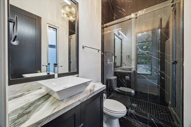 Striking en suite bath with sculptural vessel sink