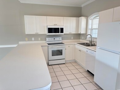 Kitchen featuring sink, white cabinetry, light til
