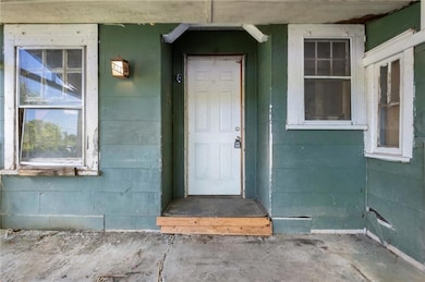 Entrance to property featuring concrete block siding