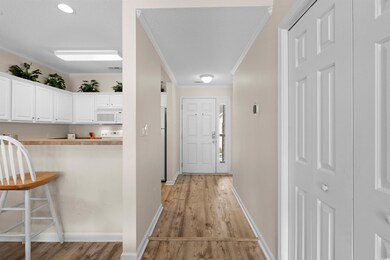 Hallway featuring light wood-style flooring and ornamental molding
