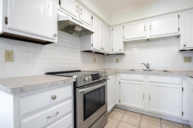 Kitchen featuring white cabinetry, stainless steel
