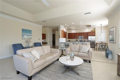 Living room featuring crown molding, light tile pa