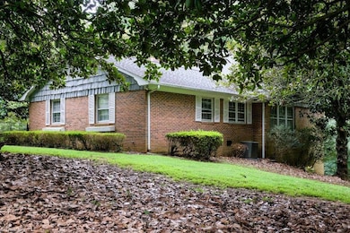 Front and side view of home, which is comprised of brick and wood shingles.