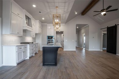 Kitchen featuring beam ceiling, a kitchen island w