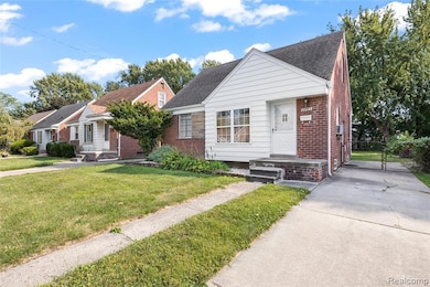 Bungalow-style house featuring brick siding, a shingled roof, a gate, and a front yard