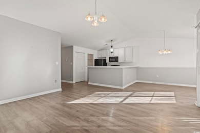 Unfurnished living room with baseboards, light woo