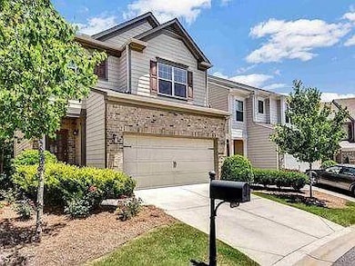 View of front of house with driveway, an attached garage, and stone siding