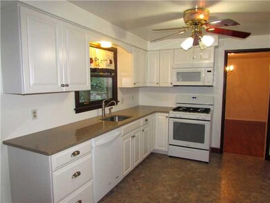 Kitchen. Neutral Toned Stone Counter Tops rest upo