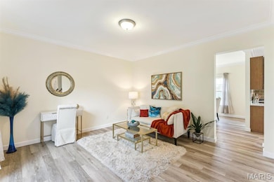 Living room featuring light wood finished floors and crown molding