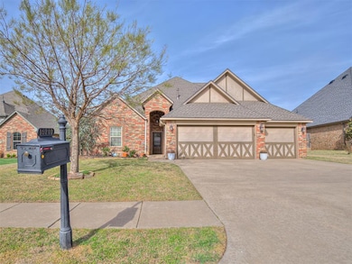 View of front of property with a front lawn, concrete driveway, brick siding, and a garage