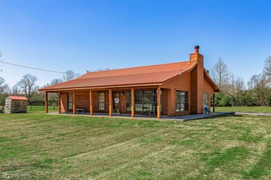 Rear view of house featuring a shed, a lawn, a chi
