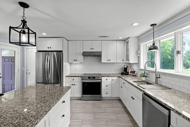 Newly remodeled kitchen with center island, granite and stainless appliances.