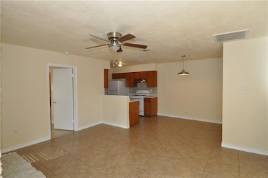Unfurnished living room featuring ceiling fan and