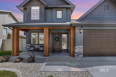 Exterior entry at dusk featuring a porch, stone siding, and an attached garage