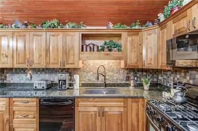 Kitchen featuring a sink, dark stone countertops, 
