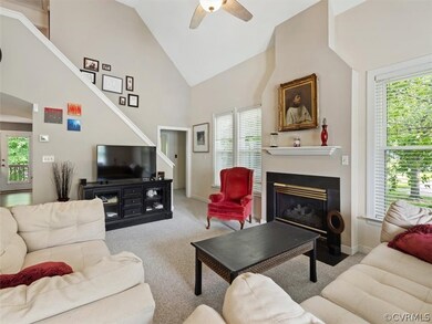 Great Room with vaulted ceilings, carpet, ceiling fan and gas fireplace.