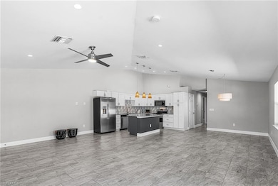 Living area with ceiling fan, high vaulted ceiling, and recessed lighting