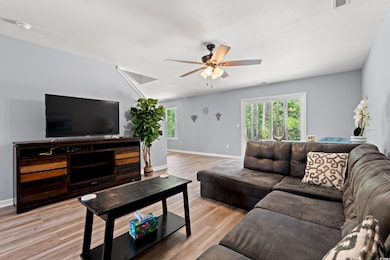 Living area with baseboards, light wood-type floor