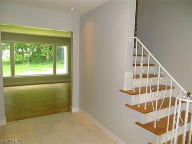 Foyer with view of living room and large window lo