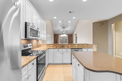 Kitchen featuring kitchen peninsula, white cabinet