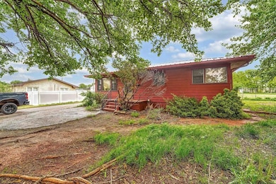 View of front of house with fence and metal roof