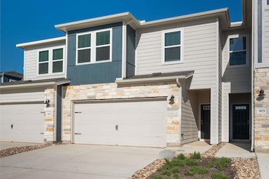 View of property with a garage, driveway, and sto